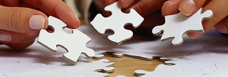 Hands Putting Jigsaw Puzzle Pieces in Place