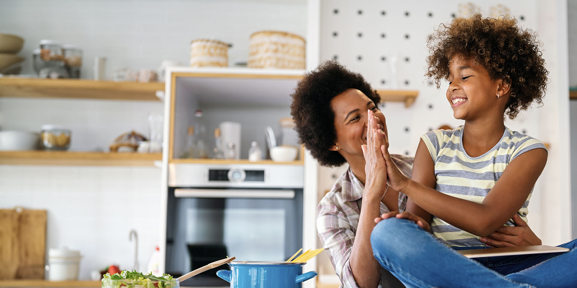 Photo of a child and adult giving each other a high five.