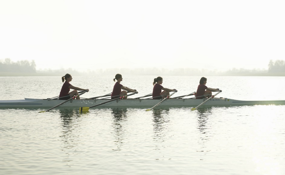 Silhouette of four females rowing, side view