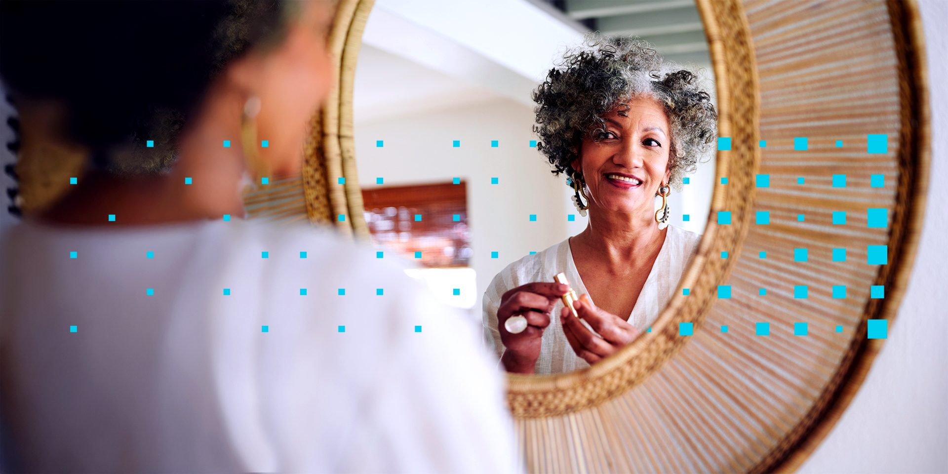 smiling women putting on lipstick in a circular mirror.