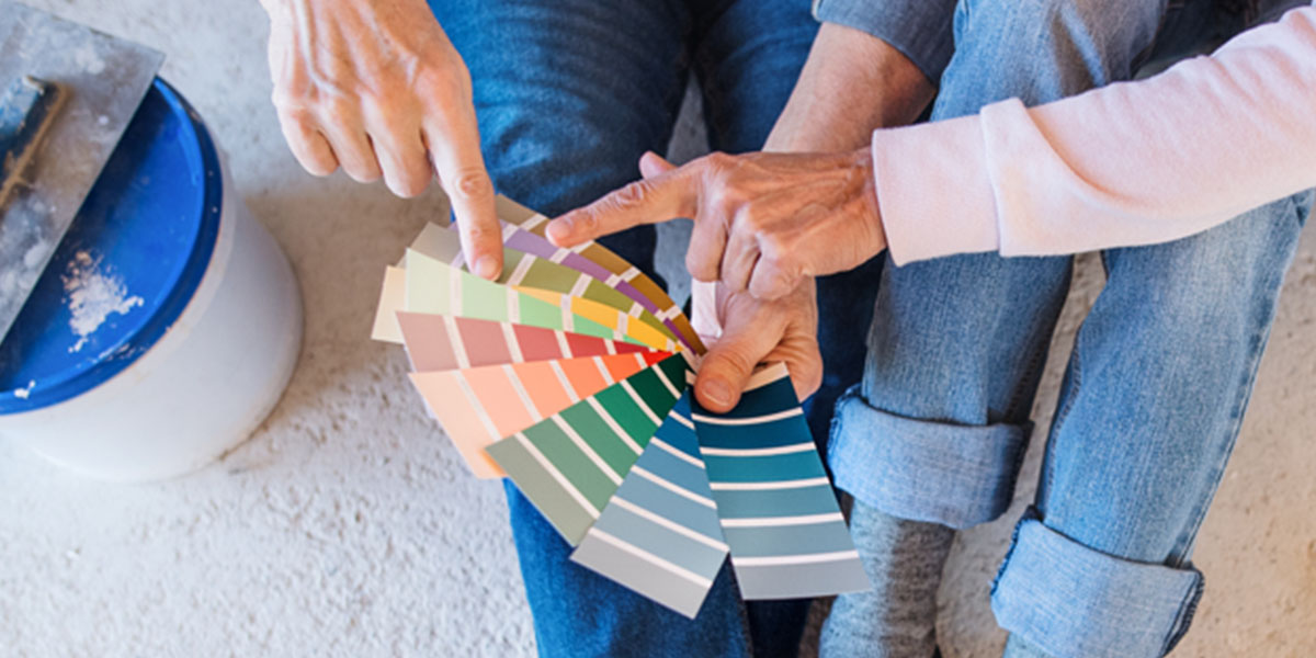 Couple looking at a paint color wheel to pick out a color of wall paint