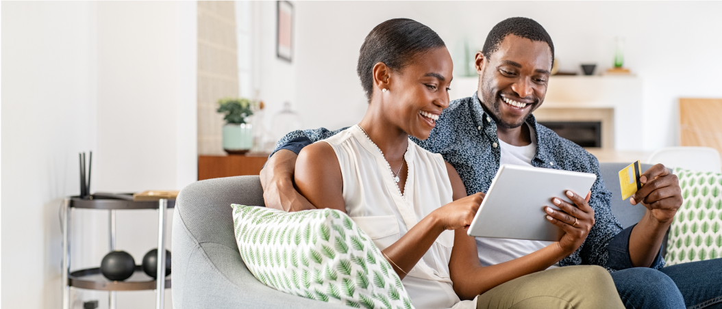 Adult couple smiling looking at tablet 