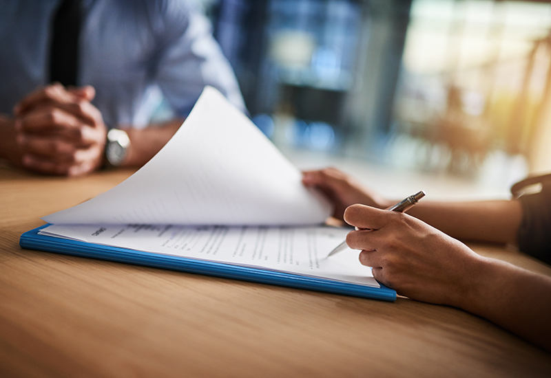 Cropped shot of a man and woman completing paperwork together at a desk