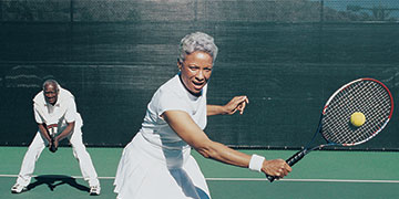 Happy healthy couple is playing tennis