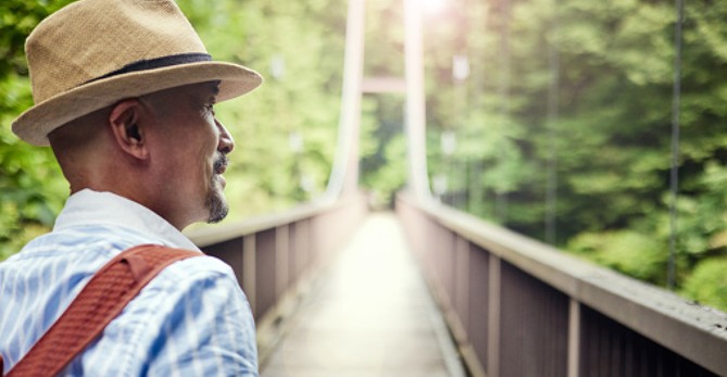 man getting ready to cross foot bridge