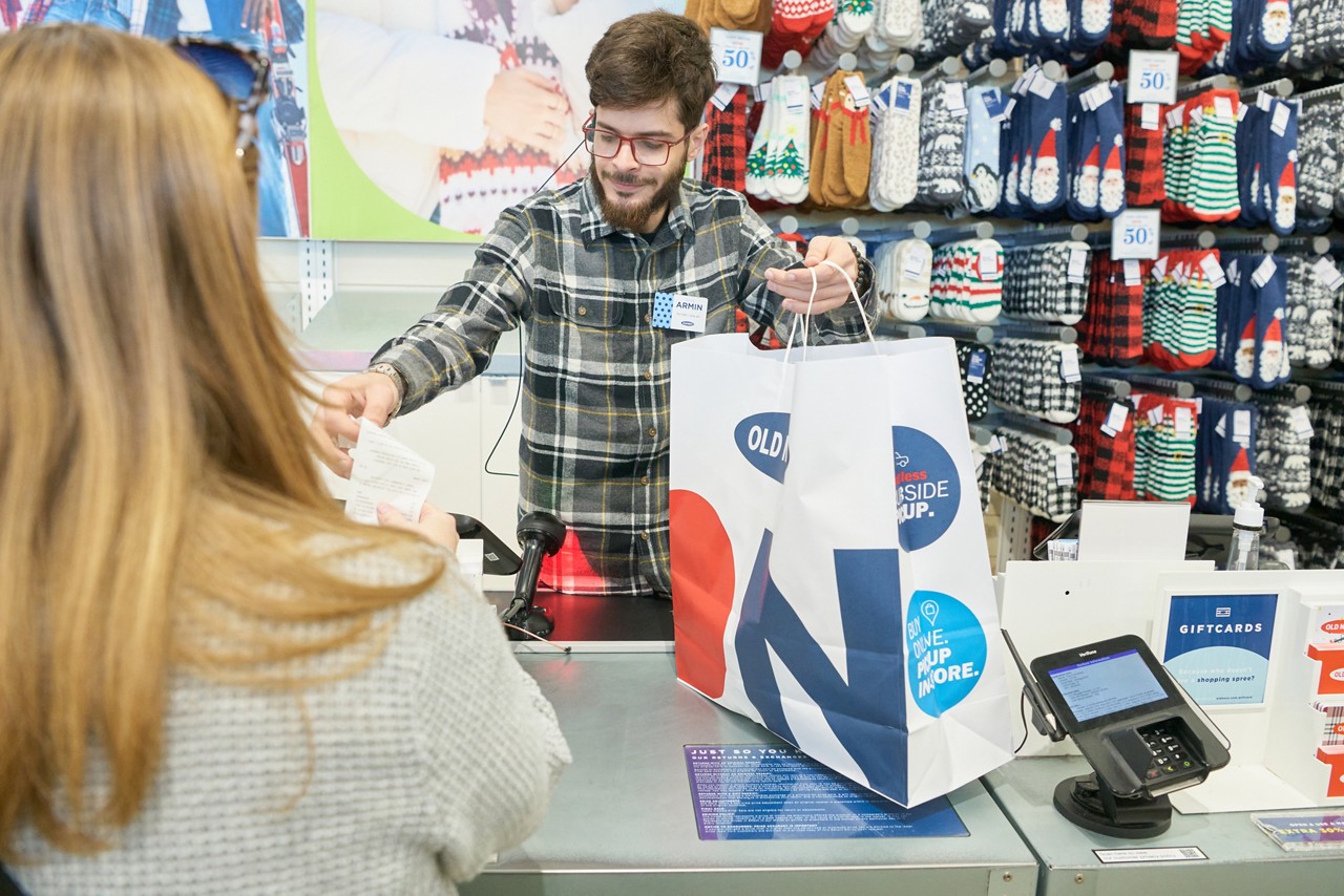 Women gather around the kitchen smiling and hugging